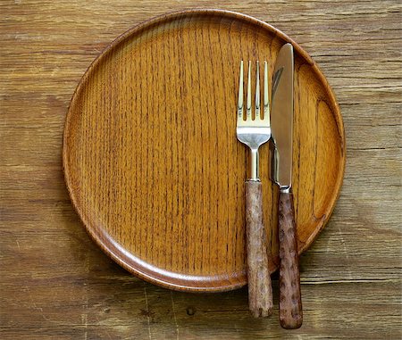 cutlery (knife and fork) on wooden plate Stock Photo - Budget Royalty-Free & Subscription, Code: 400-07555431