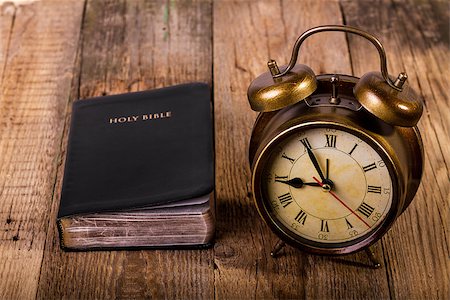 Holly Bible with clock on wood. Focus on clock. Foto de stock - Super Valor sin royalties y Suscripción, Código: 400-07555862