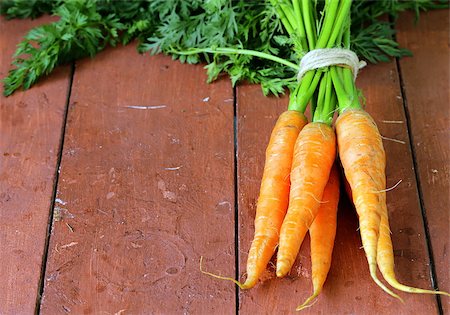 simsearch:400-07982459,k - fresh organic carrots with green leaves on a wooden background Photographie de stock - Aubaine LD & Abonnement, Code: 400-07555946