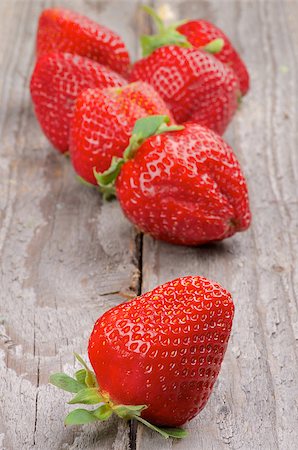 simsearch:400-08020671,k - Ripe Sweet Strawberries In a Row isolated on Rustic Wooden background Stock Photo - Budget Royalty-Free & Subscription, Code: 400-07556544