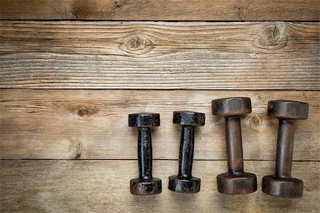 simsearch:400-07620929,k - two pairs  of vintage iron rusty dumbbells on a weathered wood background with a copy space Stock Photo - Budget Royalty-Free & Subscription, Code: 400-07550203