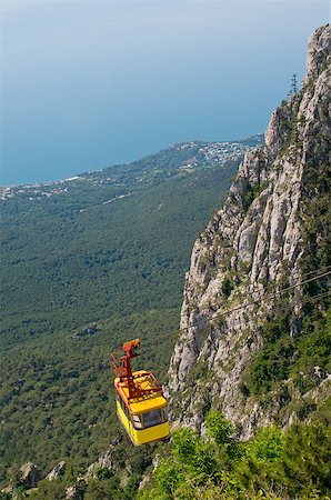 Yellow cable carriage hangs over the precipice. This cable car takes passengers from a station near Alupka to the main area in Ai-Petri (Crimea). Stock Photo - Budget Royalty-Free & Subscription, Code: 400-07550773