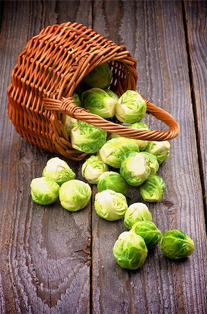 simsearch:400-06485810,k - Fresh Raw Brussels Sprouts Scattered from Wicker Basket isolated on Wooden background Fotografie stock - Microstock e Abbonamento, Codice: 400-07552372