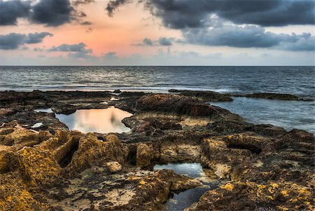 rocky beach with rock pools at sunset with cloudy sky Stock Photo - Budget Royalty-Free & Subscription, Code: 400-07552409