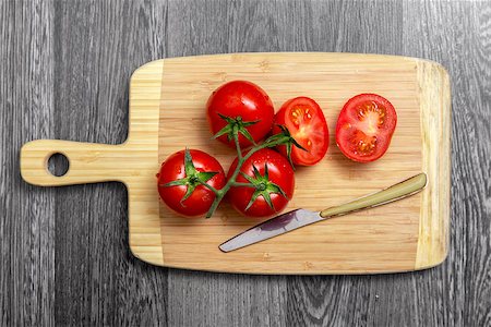 Top view of fresh tomatoes and knife on chopping board on gray table Stock Photo - Budget Royalty-Free & Subscription, Code: 400-07553503