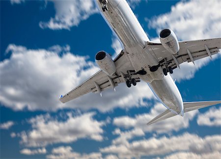 Jet Airplane Landing with Dramatic Clouds and Sky Behind. Stock Photo - Budget Royalty-Free & Subscription, Code: 400-07553572