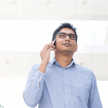 Young Asian Indian business executive on the phone, modern building at background. Stock Photo - Budget Royalty-Free & Subscription, Code: 400-07553685