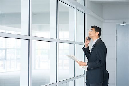 Indian man checking on new office to let, holding newspaper and calling on phone. Stock Photo - Budget Royalty-Free & Subscription, Code: 400-07553690