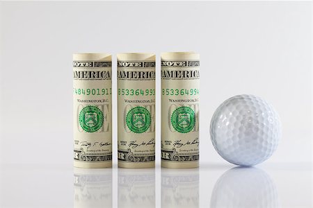 simsearch:400-07218310,k - Rolls of dollar bills and golff balls on a glass table Fotografie stock - Microstock e Abbonamento, Codice: 400-07553981