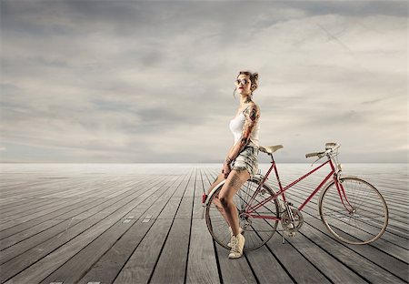 Girl sitting on a bike in a desert place Stock Photo - Budget Royalty-Free & Subscription, Code: 400-07567505