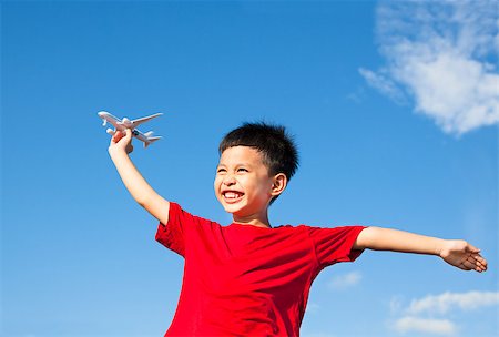 happy boy holding a airplane toy with blue sky background Stock Photo - Budget Royalty-Free & Subscription, Code: 400-07568483