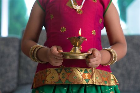 family celebrating diwali - Diwali or deepavali photo with little girl hands holding oil lamp during festival of light. Stock Photo - Budget Royalty-Free & Subscription, Code: 400-07574736