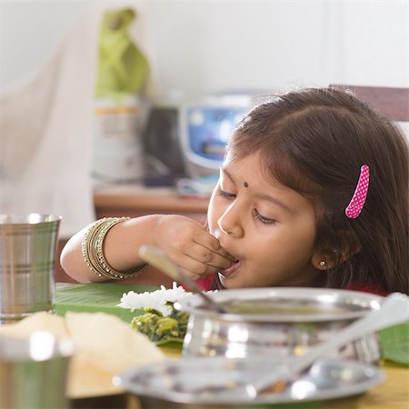 family healthy candid - Indian family dining at home. Candid photo of Asian child self feeding rice with hand. India culture. Stock Photo - Budget Royalty-Free & Subscription, Code: 400-07574741