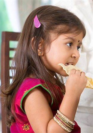 family healthy candid - Indian family dining at home. Candid photo of Asian child self feeding snack papadum. India culture. Stock Photo - Budget Royalty-Free & Subscription, Code: 400-07574742