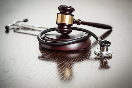 simsearch:400-05358699,k - Gavel and Stethoscope on Reflective Wooden Table. Photographie de stock - Aubaine LD & Abonnement, Code: 400-07574794