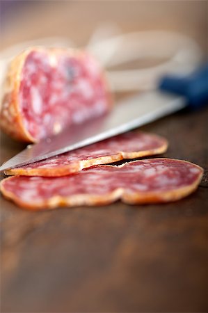 simsearch:400-06852716,k - slicing italian salame pressato pressed over old wood table Stockbilder - Microstock & Abonnement, Bildnummer: 400-07576011