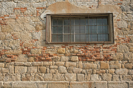 simsearch:400-08615330,k - Old stone wall with fallen plaster and window with bars Stock Photo - Budget Royalty-Free & Subscription, Code: 400-07576232