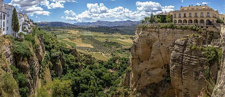 Ronda panoramic view. A city in the Spanish province of Málaga, within the autonomous community of Andalusia. Is situated in a very mountainous area about 750 m above mean sea level. The Guadalevín River runs through the city, dividing it in two and carving out the steep, 100 plus meters deep El Tajo canyon upon which the city perches Foto de stock - Super Valor sin royalties y Suscripción, Código: 400-07577627