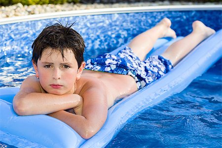 Happy young boy with inflatable water lounger in the swimming pool Foto de stock - Super Valor sin royalties y Suscripción, Código: 400-07577954