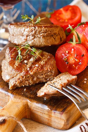 simsearch:400-08495308,k - Juicy beef steak with tomato salad served on an old wooden cutting board. Stockbilder - Microstock & Abonnement, Bildnummer: 400-07578192