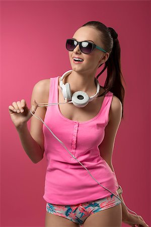 funny sexy girl with pink singlet, panties and sunglasses listening music with headphones Stock Photo - Budget Royalty-Free & Subscription, Code: 400-07578414