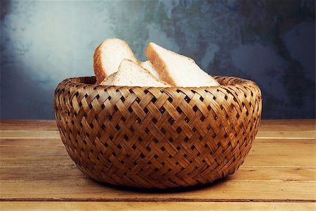 Slices of bread in wicker breadbasket on wooden table Stock Photo - Budget Royalty-Free & Subscription, Code: 400-07578981