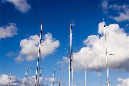 photojope (artist) - Some sailboat masts on a blue sky with clouds background. Photographie de stock - Aubaine LD & Abonnement, Code: 400-07579116