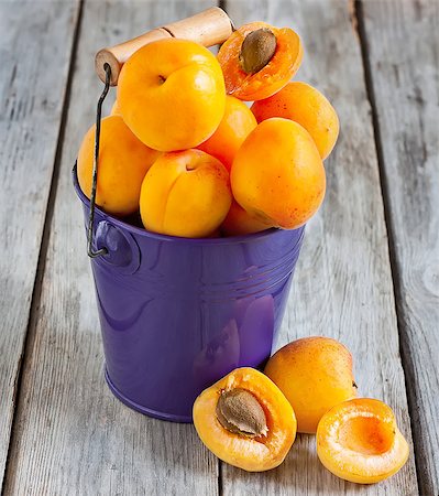 Sweet ripe apricots in small violet bucket. Selective focus. Stock Photo - Budget Royalty-Free & Subscription, Code: 400-07579334