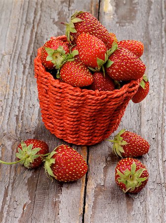 simsearch:400-08020671,k - Fresh Ripe Forest Strawberries in Red Wicker Basket isolated on Rustic Wooden background Stock Photo - Budget Royalty-Free & Subscription, Code: 400-07579910