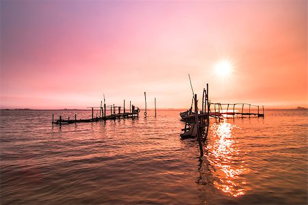 simsearch:400-08812531,k - Old fishing dock sunrise and calm water reflection. Fotografie stock - Microstock e Abbonamento, Codice: 400-07570219