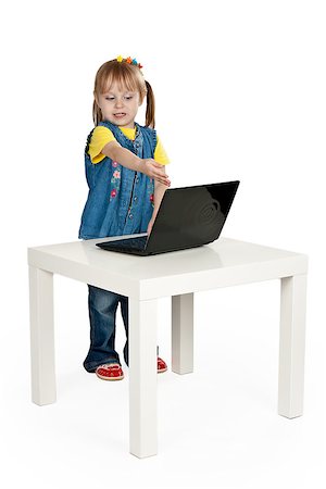 little girl with a laptop at a table on a gray background Stock Photo - Budget Royalty-Free & Subscription, Code: 400-07570429