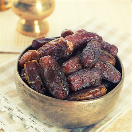 Dried date palm fruits or kurma, ramadan food which eaten in fasting month. Pile of fresh dried date fruits ready to eat in metal bowl. Stock Photo - Budget Royalty-Free & Subscription, Code: 400-07570582