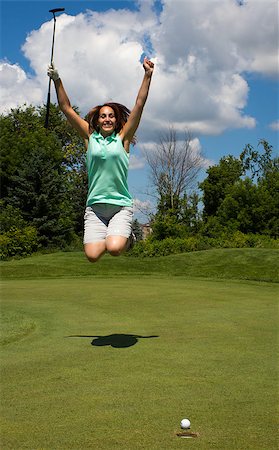 Woman jumps for joy as the ball heads into the cup on the golf green Stock Photo - Budget Royalty-Free & Subscription, Code: 400-07572514