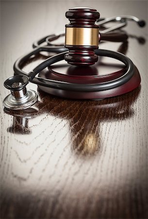 simsearch:400-05358699,k - Gavel and Stethoscope on Reflective Wooden Table. Photographie de stock - Aubaine LD & Abonnement, Code: 400-07573276