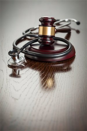 simsearch:400-05358699,k - Gavel and Stethoscope on Reflective Wooden Table. Photographie de stock - Aubaine LD & Abonnement, Code: 400-07573278