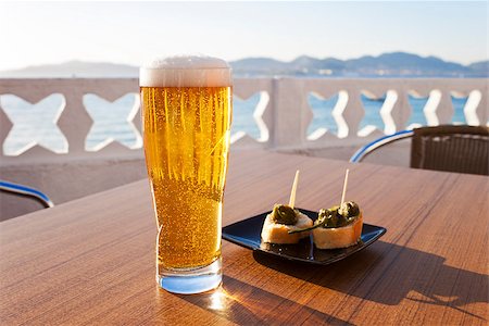 photojope (artist) - Glass of cold beer and a plate of green peppers in the table of a terrace next to the sea in Spain. Fotografie stock - Microstock e Abbonamento, Codice: 400-07573356