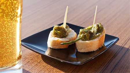 photojope (artist) - Small green peppers (Padron peppers) with bread bites in a plate with a glass of beer in a table. Photographie de stock - Aubaine LD & Abonnement, Code: 400-07573359
