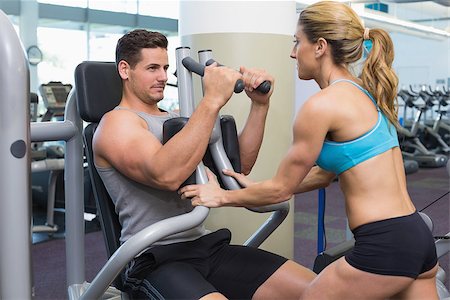 simsearch:400-06801597,k - Personal trainer coaching bodybuilder using weight machine at the gym Stock Photo - Budget Royalty-Free & Subscription, Code: 400-07584125