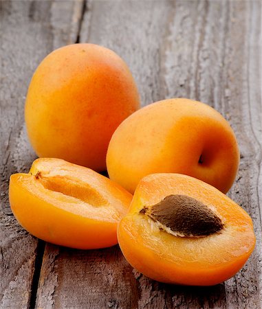 simsearch:400-08012355,k - Two Ripe Full Body Apricots and Halves isolated on Rustic Wooden background Photographie de stock - Aubaine LD & Abonnement, Code: 400-07580871