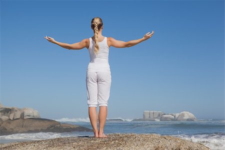 Blonde woman standing on beach on rock with arms out on a sunny day Stock Photo - Budget Royalty-Free & Subscription, Code: 400-07581046