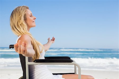 Wheelchair bound blonde smiling on the beach on a sunny day Stock Photo - Budget Royalty-Free & Subscription, Code: 400-07581128