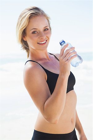 simsearch:400-07581190,k - Fit blonde drinking water on the beach on a sunny day Photographie de stock - Aubaine LD & Abonnement, Code: 400-07581206