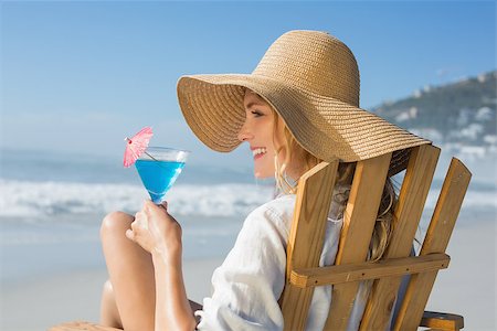 sunbed and cocktail - Smiling blonde relaxing in deck chair by the sea holding cocktail on a sunny day Stock Photo - Budget Royalty-Free & Subscription, Code: 400-07581649