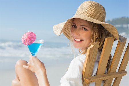 sunbed and cocktail - Smiling blonde relaxing in deck chair by the sea holding cocktail on a sunny day Stock Photo - Budget Royalty-Free & Subscription, Code: 400-07581650