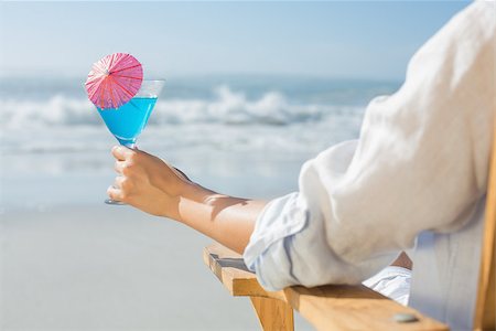 sunbed and cocktail - Woman relaxing in deck chair by the sea holding cocktail on a sunny day Stock Photo - Budget Royalty-Free & Subscription, Code: 400-07581652