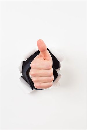 Thumbs up bursting through paper on white background Stock Photo - Budget Royalty-Free & Subscription, Code: 400-07582275