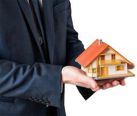 Businessman holding miniature house model on white background Stock Photo - Budget Royalty-Free & Subscription, Code: 400-07582311