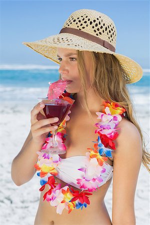 Pretty blonde in floral garland sipping cocktail on the beach on a sunny day Stock Photo - Budget Royalty-Free & Subscription, Code: 400-07582574