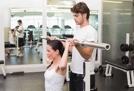 posição - Fit woman lifting barbell with her trainer spotting at the gym Foto de stock - Royalty-Free Super Valor e Assinatura, Número: 400-07583191