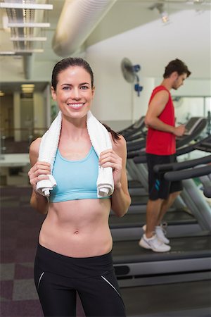 Smiling brunette with towel over shoulders at the gym Stock Photo - Budget Royalty-Free & Subscription, Code: 400-07583205